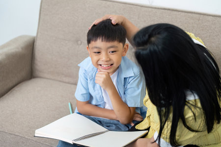 Back to School. Child smiling while studying with mother at home.の写真素材