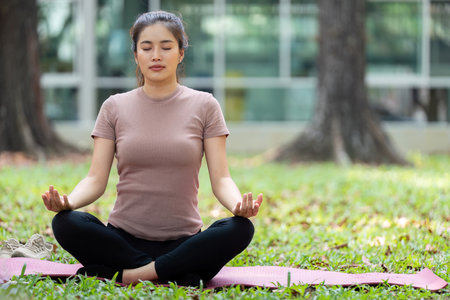 Wellness through Meditation. Young woman practicing mindfulness outdoors in a serene park.