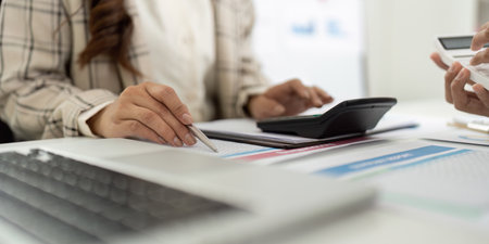 Detailed Financial Analysis. Close-up of accountants hands working with reports and calculator.