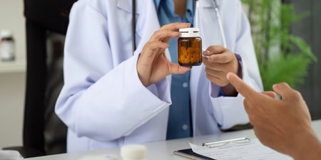 Health and Wellness. Doctor discussing medication with patient in a clinical setting.の写真素材