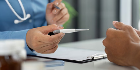 Health and Wellness. Nurse holding thermometer during patient consultation.の写真素材