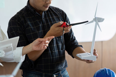 Sustainability and Engineering. Engineers analyzing wind turbine models for renewable energy...