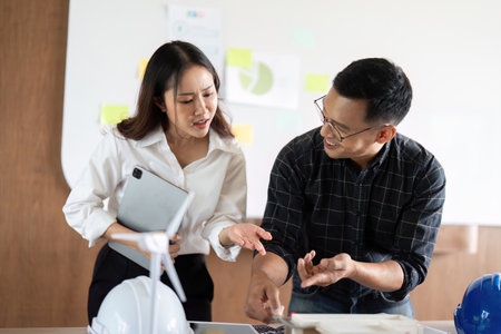 Sustainability and Engineering. Engineers analyzing project details with eco-friendly models.の写真素材