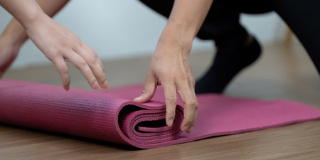 Wellness and Couple Bonding. Two individuals preparing yoga mats for a shared exercise session.の写真素材