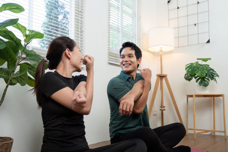 Two partners engaging in stretching exercises at home for fitness and relaxation.