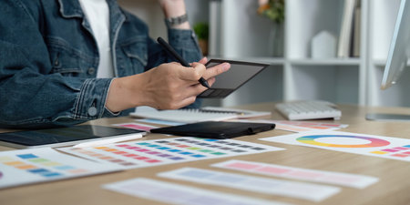 Design Workflow. Professional designer creating digital concepts with tablet and color samples.