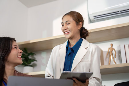 Positive Interaction. Professionals sharing insights and smiling.の写真素材