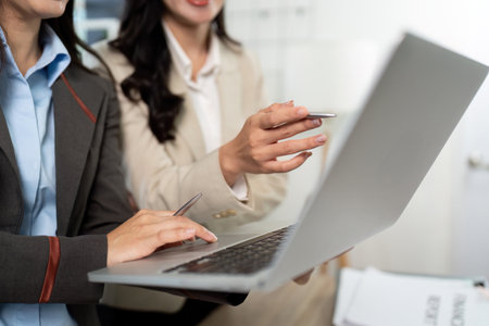 Business Professionals Engaging with Technology. Team discussing strategies on a laptop.の写真素材