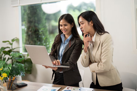 Engaging Business Discussion. Team reviewing data on a laptop in a modern office.の写真素材