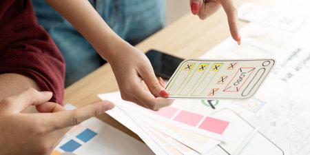 Hands Holding User Interface Design Concepts for Review