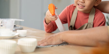 Cleaning and Baking. Child and mother enjoying a fun kitchen cleaning activity together.の写真素材