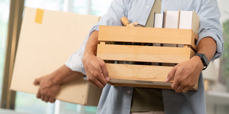 Joyful gay couple unpacking boxes together in their new apartment