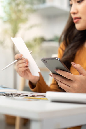 Financial Organization. Person holding smartphone and bills, managing expenses.