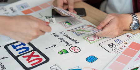 UX UI Design Process. Hands exchanging design cards during a creative meeting.の写真素材