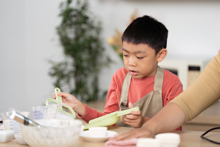 Kitchen Cleaning Activity. A child learning to clean while helping in the kitchen.の写真素材
