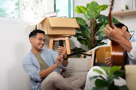 Gay couple enjoying moments while unpacking boxes in their new homeの写真素材
