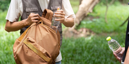 Hiking Essentials: Young Man Packing Water Bottles in Backpackの写真素材