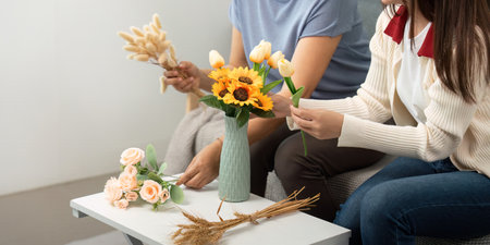 Mother and Daughter Enjoying Floral Arrangement Crafting. A Creative Bonding Experience.の写真素材