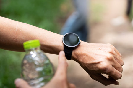 Close-Up of Smartwatch and Water Bottle. A detailed view of a smartwatch and water bottle during a...