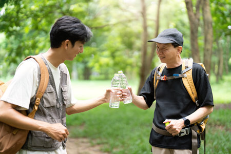 Father and Son Hydrating During Hike. A father and son sharing water on their outdoor adventure.の写真素材