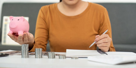 Financial Empowerment: Woman Managing Savings with Piggy Bankの写真素材