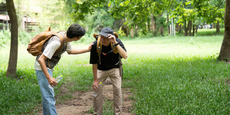 Father Helping Son During Hike. A father provides support to his son on a challenging trail.の写真素材