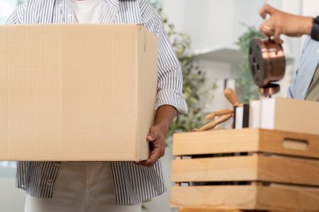 Gay couple unpacking boxes together in a cozy home environmentの写真素材
