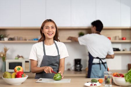 Happy Couple Cooking Together in Kitchen. Enjoying healthy meal preparation and laughter.の写真素材