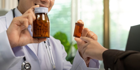 Patient Interaction. Doctor handing medication to patient during consultation.の写真素材