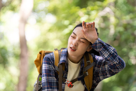 Hiking Challenge: Young Woman Feeling Exhausted in Natureの写真素材