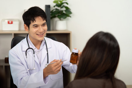 Friendly Doctor Interaction. Physician showing medication to patient during appointment.の写真素材