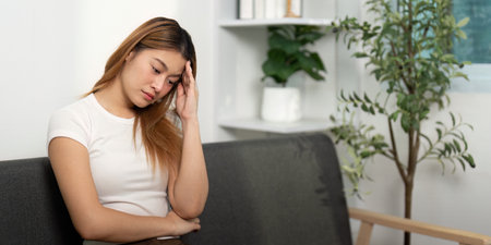 Mental Health: Young woman with a pensive expression, showing signs of stress.の写真素材