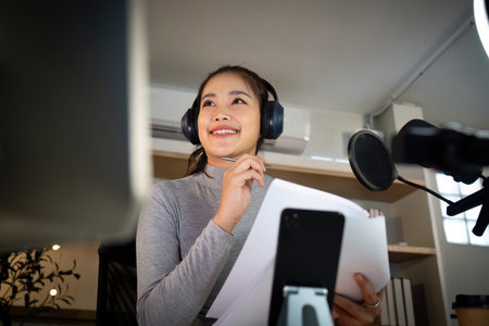 Podcast host enjoying a moment of inspiration during recordingの写真素材
