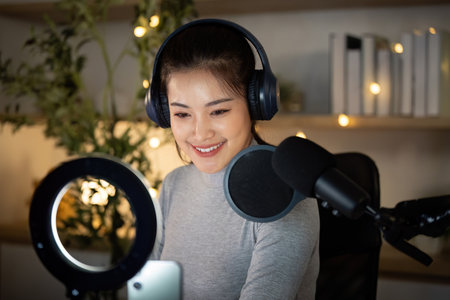 Podcasting. Engaging woman recording her podcast with microphone and headphones.の写真素材