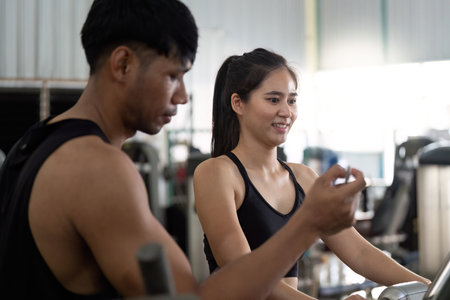 Trainer assisting young woman during gym workoutの写真素材