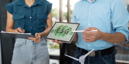 ESG discussion. Professionals presenting sustainability strategies with digital tools in a modern...