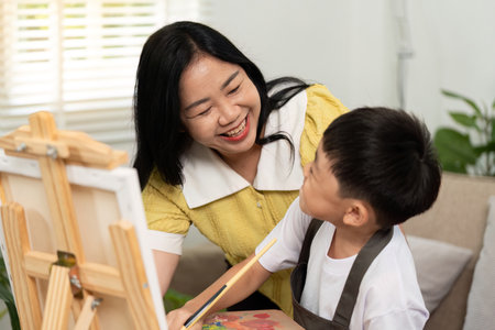 Artistic Connection. Mother encouraging son during painting session.