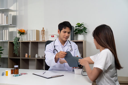Patient Consultation. Doctor explaining health information to young woman.の写真素材
