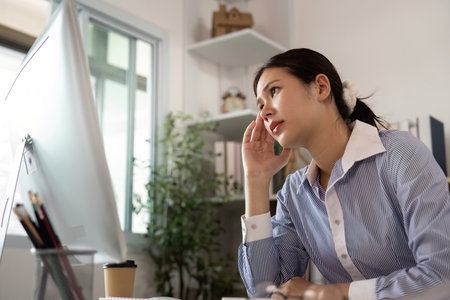 Office Syndrome: Young woman contemplating while working at her desk