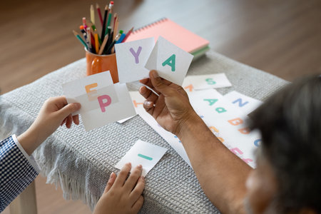 Educational Engagement. Grandfather and child exploring letters with flashcards.