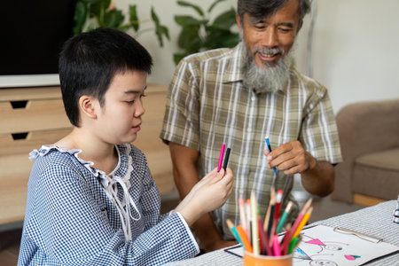 Artistic Interaction. Grandfather and child sharing colorful markers.の写真素材