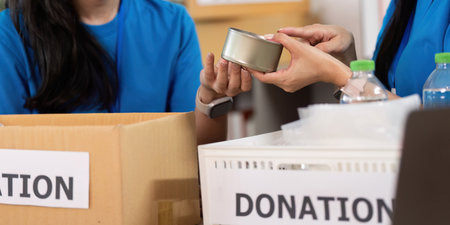 Volunteer collaboration. Close-up of women exchanging donation items with care.