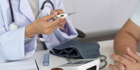 Temperature Check. Nurse using thermometer while monitoring patient health.