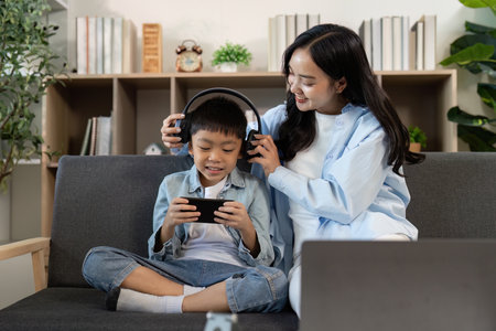 Fun Moments. Mother and son enjoying gaming together with headphones.