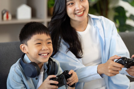 Joyful Gaming Experience. Mother and son sharing smiles while playing video games.の写真素材