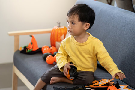 Halloween Fun. Young child playing with festive decorations at home.の写真素材