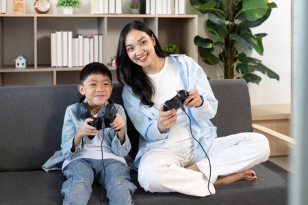 Mother and son playing video games together at home