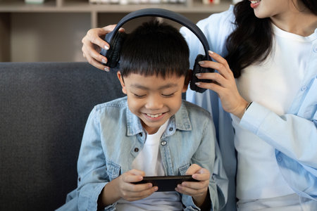 Joyful Moments. Mother and son sharing laughter while enjoying music.