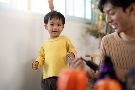 Joyful Moments: Child and Parent Engaging in Pumpkin Painting for Halloween