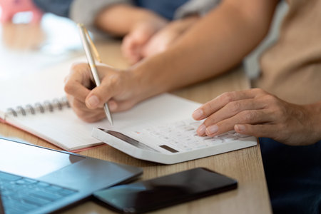 Financial Planning. Adult calculating expenses with calculator and notebook.